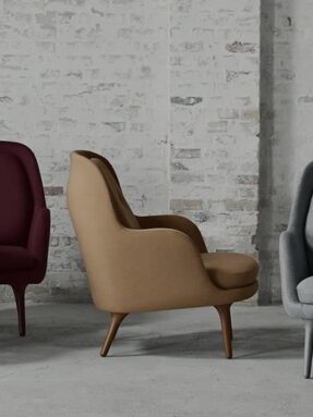 A group of three chairs in front of a brick wall.
