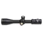 A black rifle scope with a yellow dot on it.