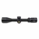 A black rifle scope with a yellow dot on it.