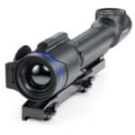 A rifle scope with blue ring on it.