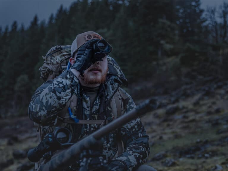A man in camouflage taking pictures with his camera.